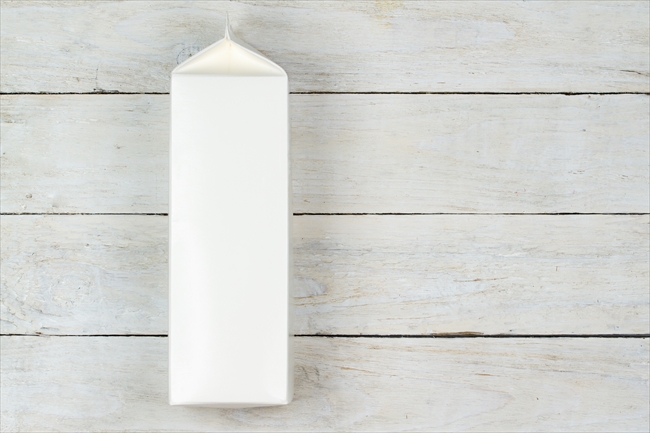 Blank cardboard milk pack on wooden table